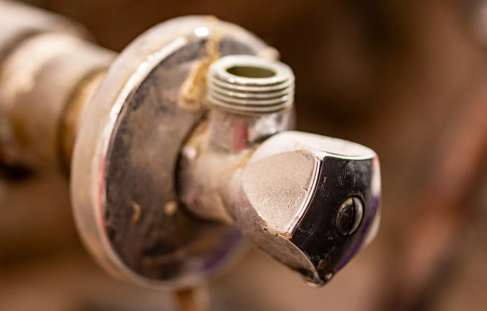 Close-up of a worn shut-off valve on a household water supply line