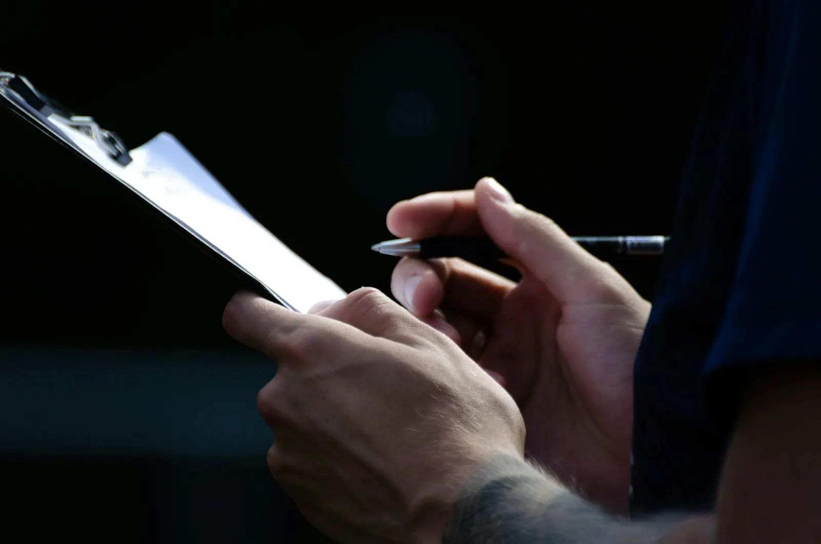 Hands taking notes on a clipboard during an inspection