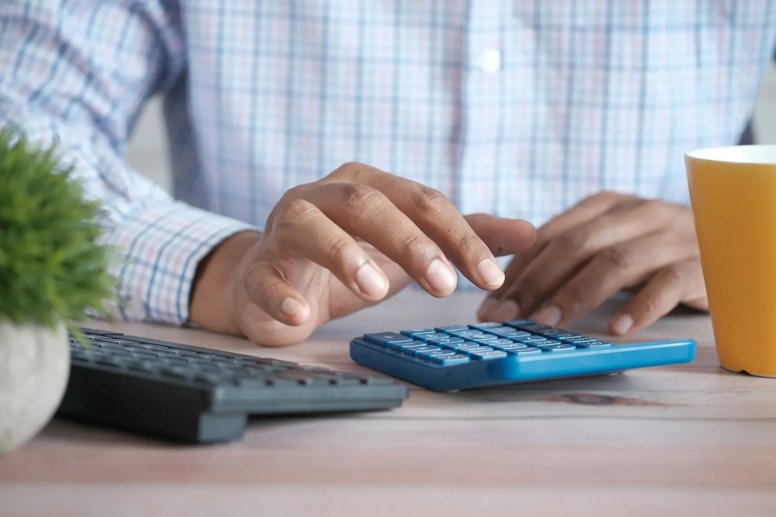 Hands using a calculator at a desk to work through deductible math