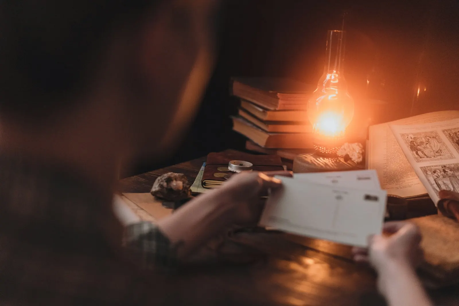 Homeowner reading a letter by lamplight at a desk covered with papers