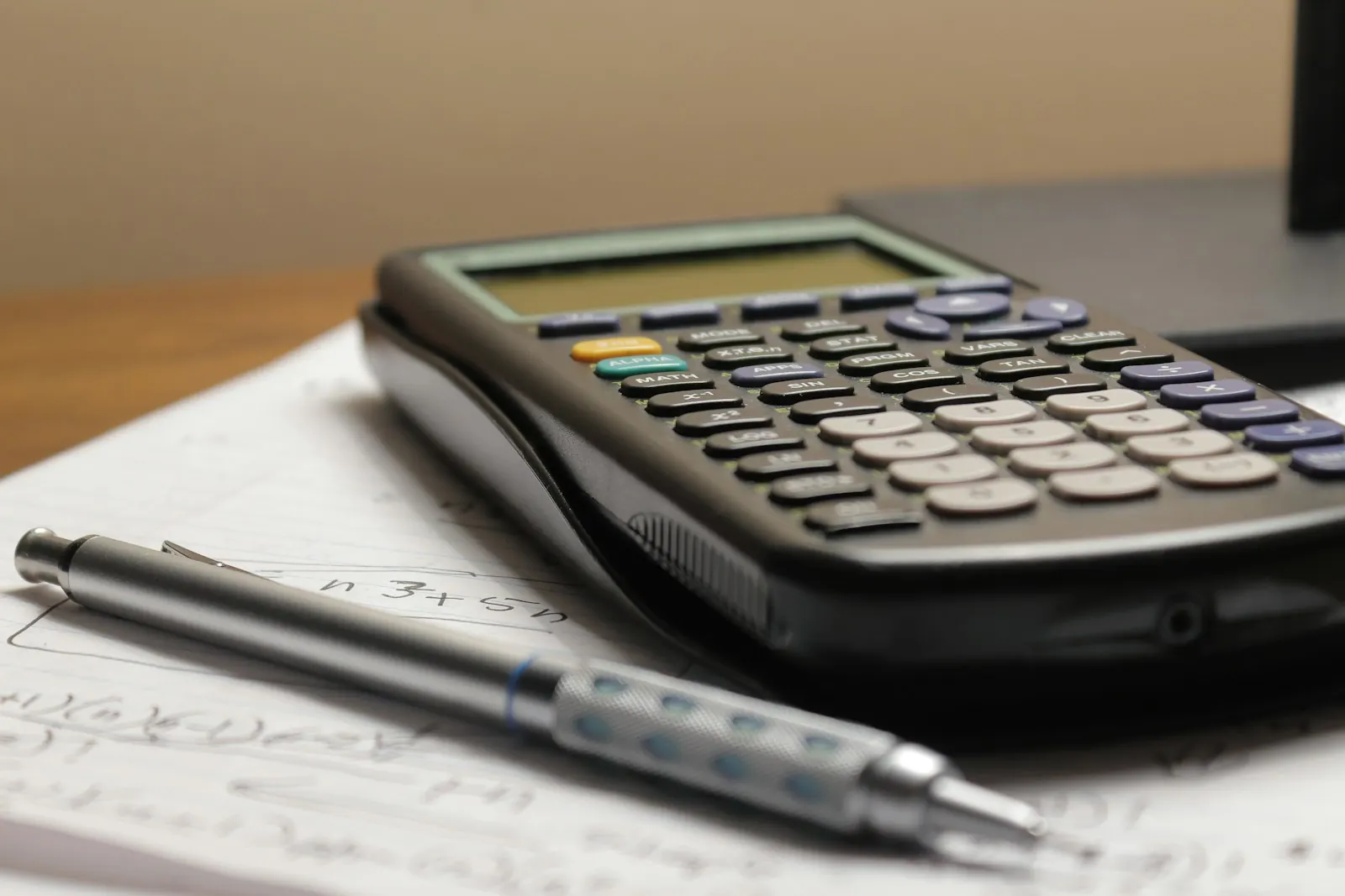 Calculator and mechanical pencil on handwritten estimate notes