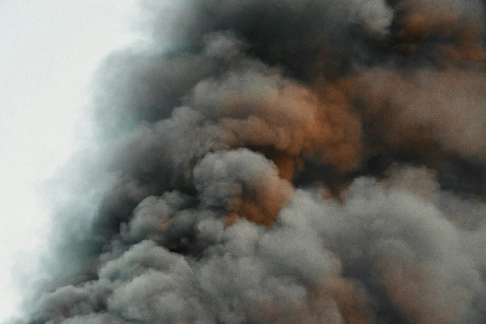 Thick dark smoke billowing into the sky